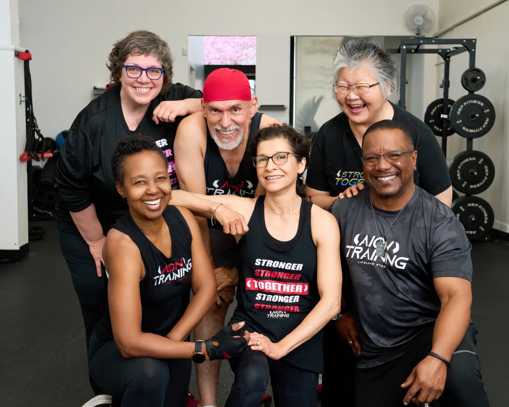A group of members and coaches gathered together for a photo in the studio.