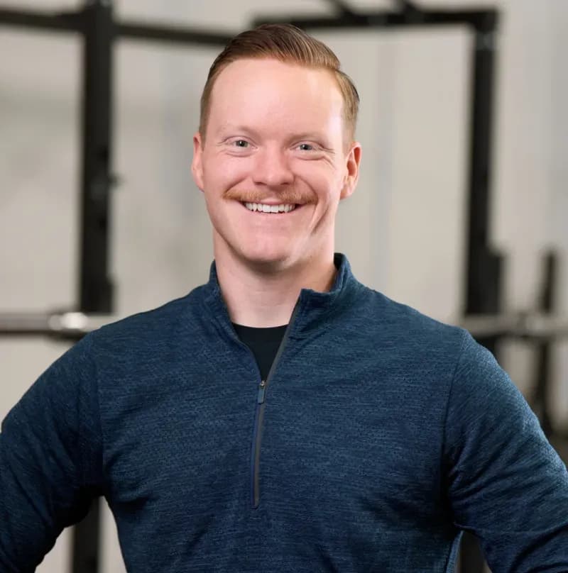 Shawn Clifford, facility leader at Aion Personal Training, smiling in a blue quarter zip.