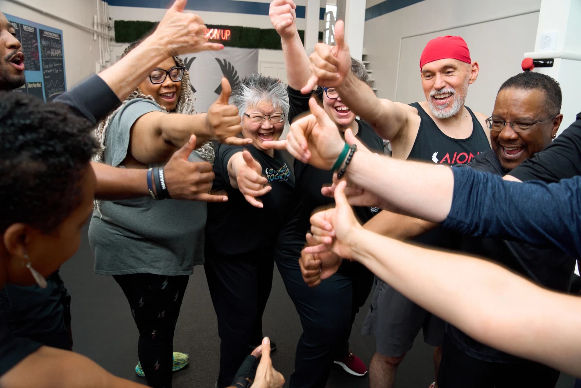 Members and coaches reach in and stack their hands together after a team session.